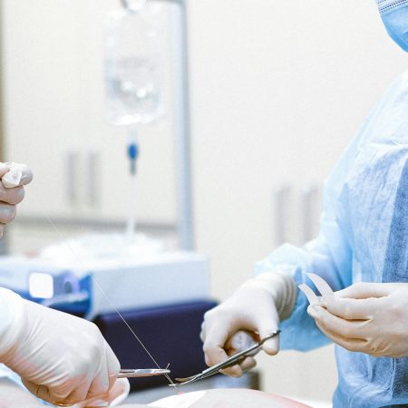 Healthcare professionals in protective gear engaged in a surgical procedure.