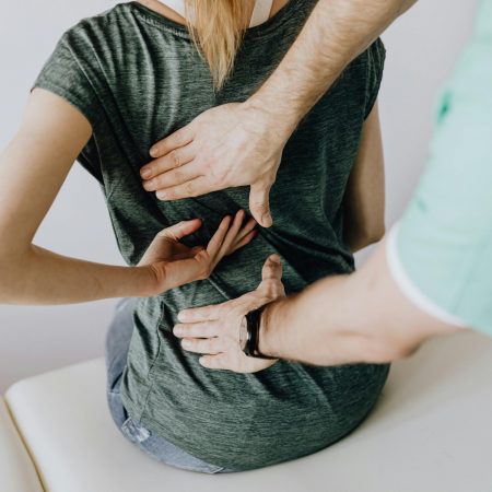 A chiropractor examining a patient's back to alleviate pain and discomfort.
